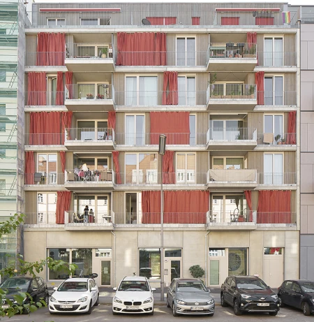 Straßenansicht des Ausbauhauses in Berlin-Südkreuz. Das Gebäude ist von einer Holzfassade und bodentiefen Fenstern geprägt.