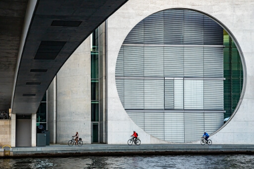 3 Radfahrer am Ufer der Spree in Berlin. 