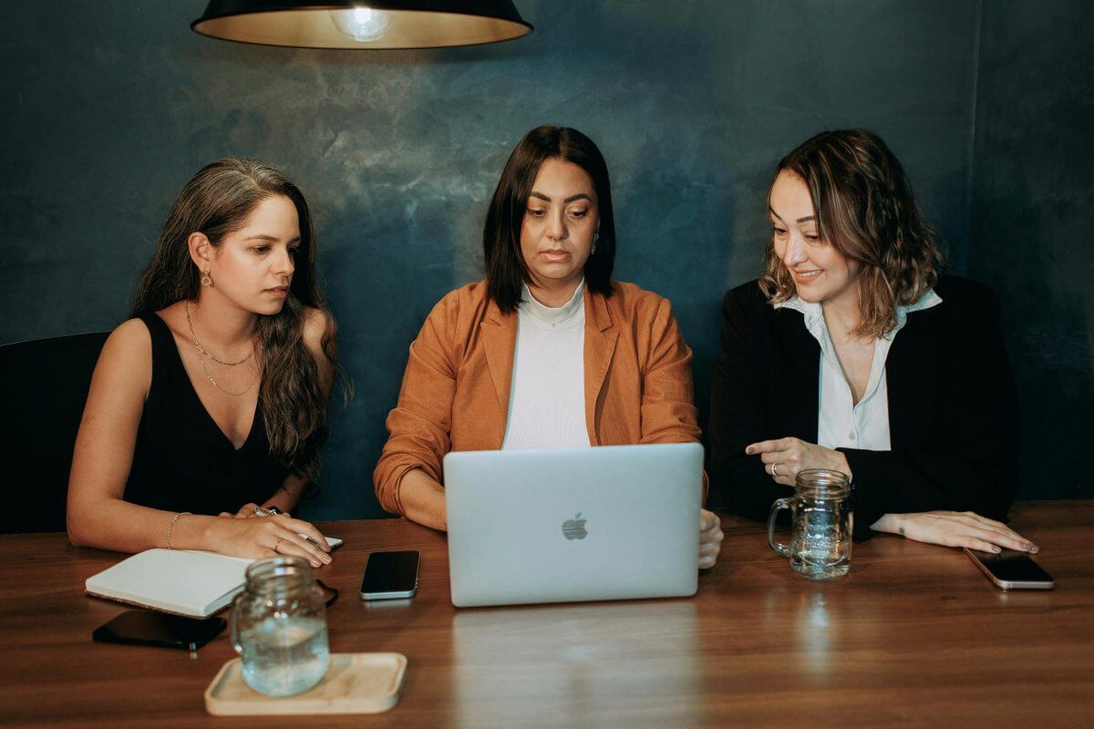 3 Frauen in einer Beratung vor dem Laptop. 