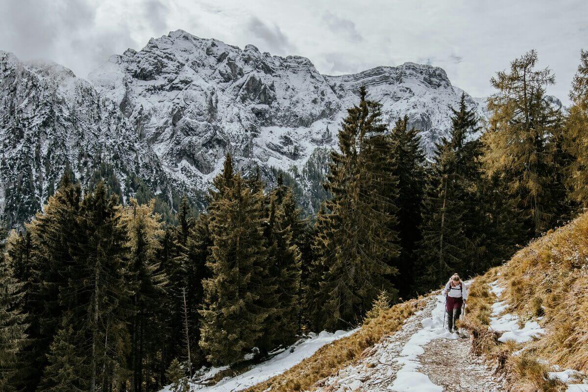 Eine Frau wandert in einer schneebedeckten Berglandschaft. 