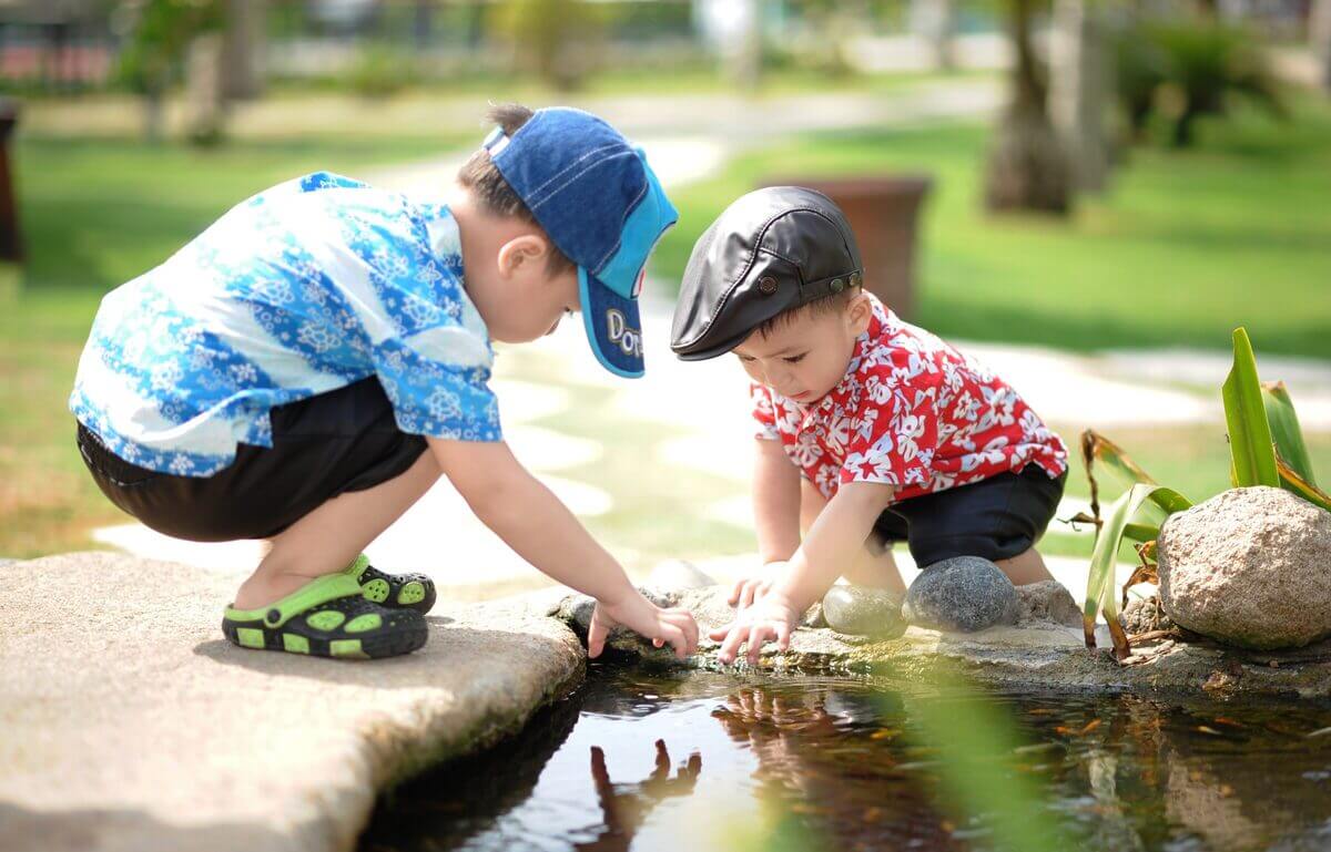 Zwei kleine Jungen spielen in einem Park. 