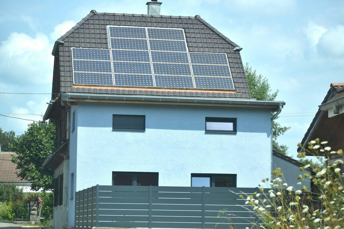 Ein Haus mit einer Solaranlage auf dem Dach. 
